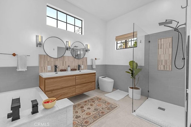 bathroom with toilet, a shower, tile patterned flooring, tile walls, and vanity