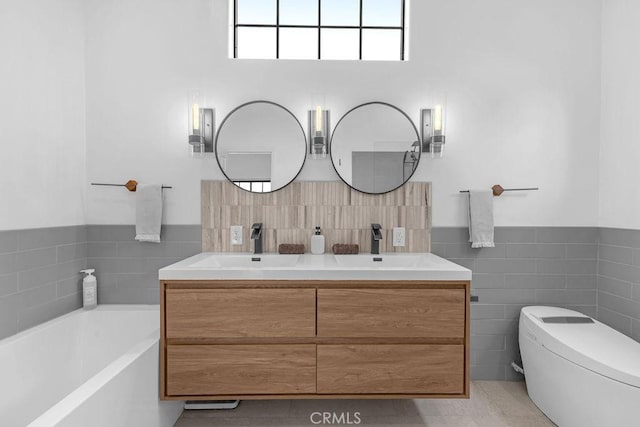 bathroom with toilet, tile patterned floors, a washtub, and vanity