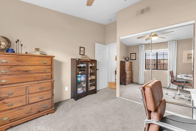 carpeted office space featuring ceiling fan