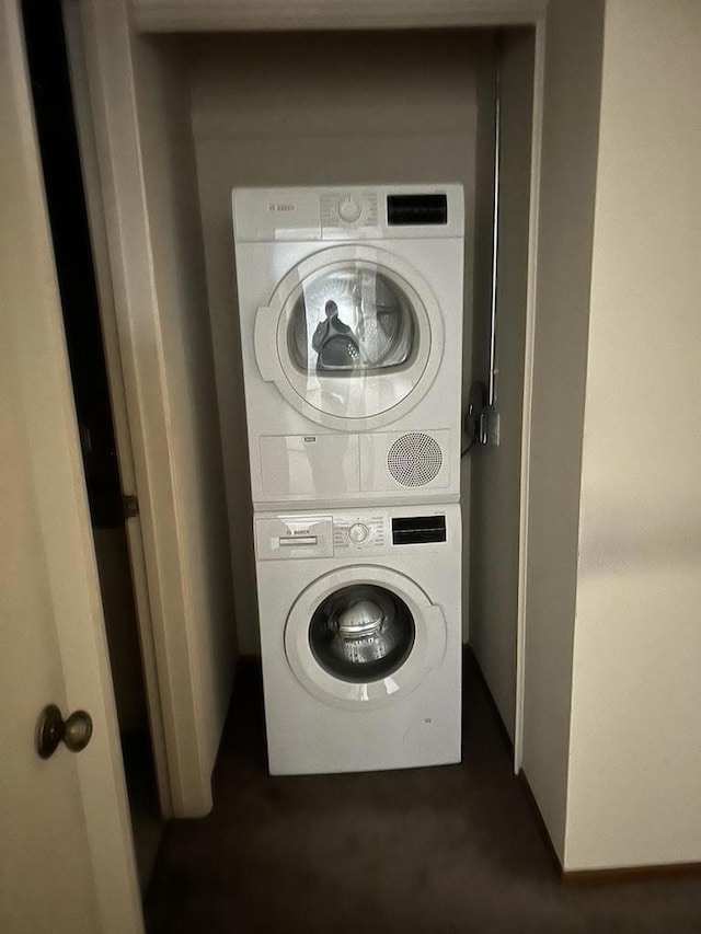 clothes washing area featuring stacked washing maching and dryer