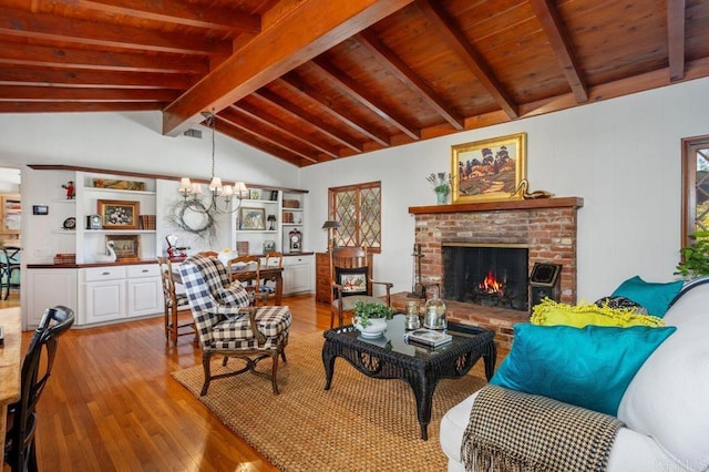 living room with a notable chandelier, light hardwood / wood-style flooring, a brick fireplace, lofted ceiling with beams, and wood ceiling