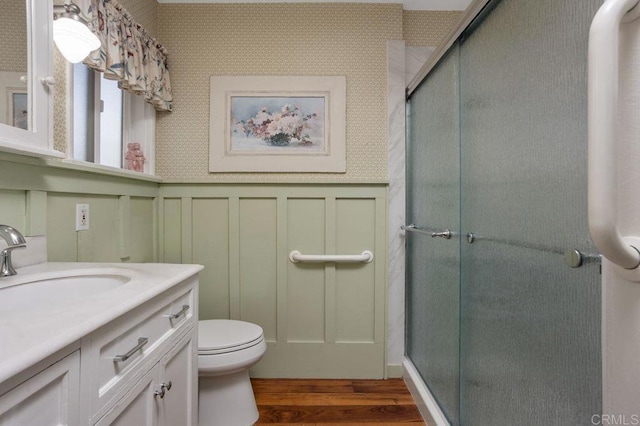 bathroom featuring walk in shower, toilet, vanity, and wood-type flooring