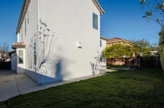 view of side of property with a yard and a patio