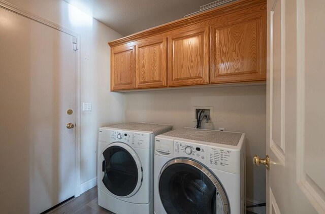 laundry room with washer and dryer and cabinets