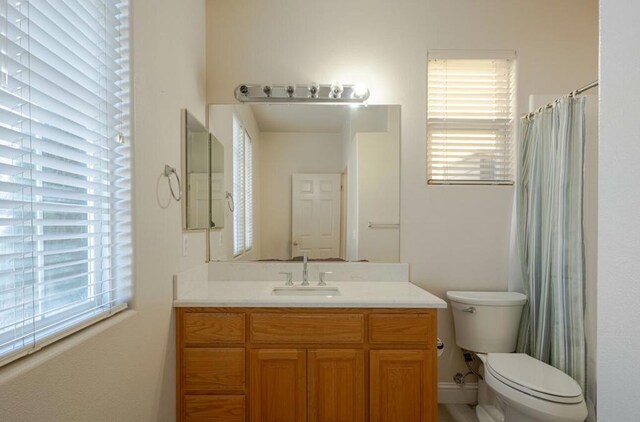 bathroom with toilet, walk in shower, and vanity