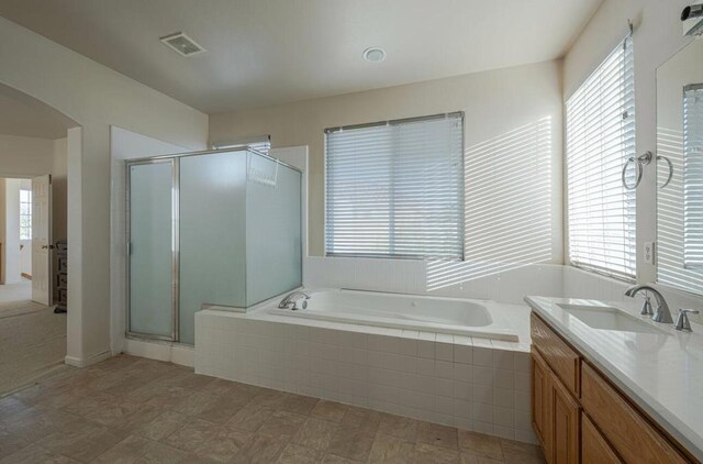 bathroom with vanity and independent shower and bath