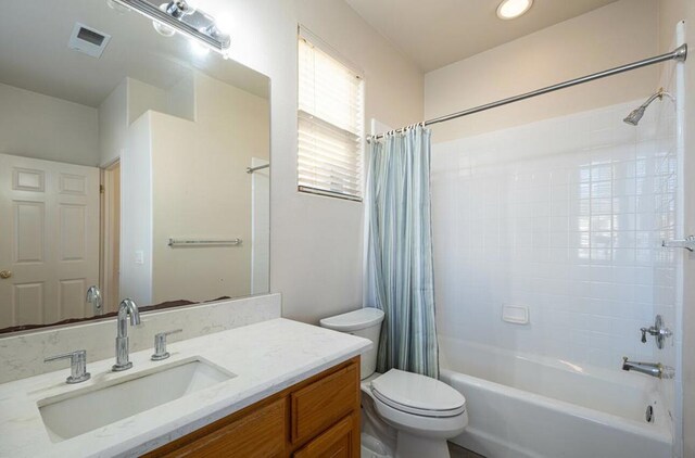 full bathroom featuring toilet, vanity, and shower / bath combination with curtain