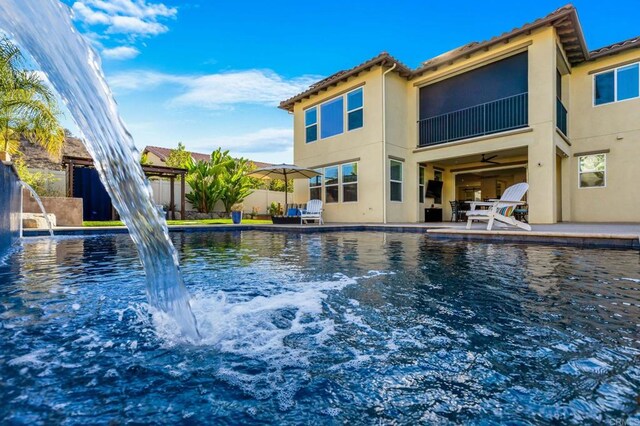 view of swimming pool featuring pool water feature and a patio area