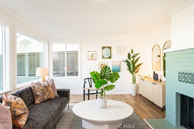 living room featuring a brick fireplace, plenty of natural light, dark hardwood / wood-style floors, and crown molding