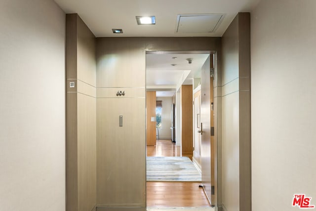 corridor with light hardwood / wood-style floors