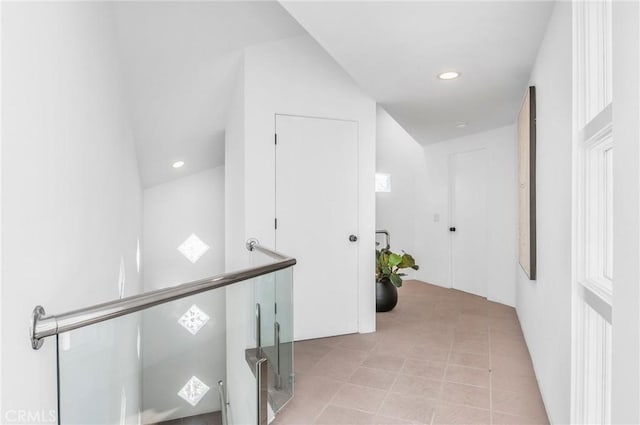 corridor featuring light tile patterned floors and lofted ceiling