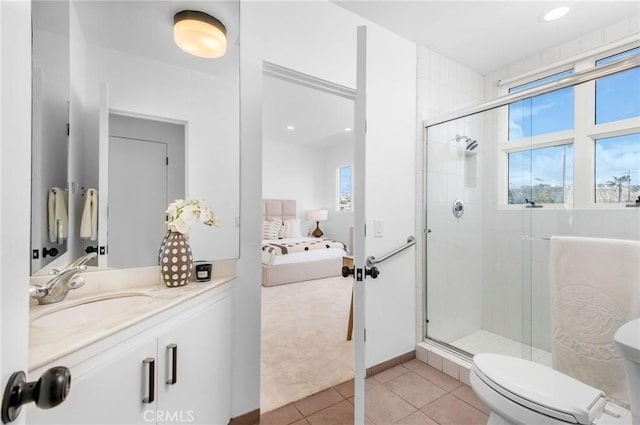 bathroom with toilet, tile patterned floors, vanity, and a shower with shower door