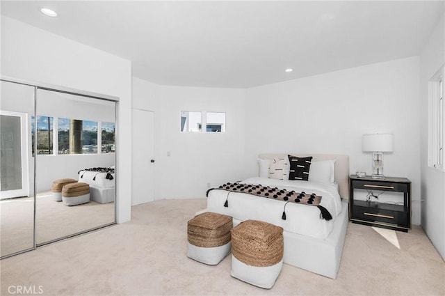 carpeted bedroom featuring multiple windows and a closet