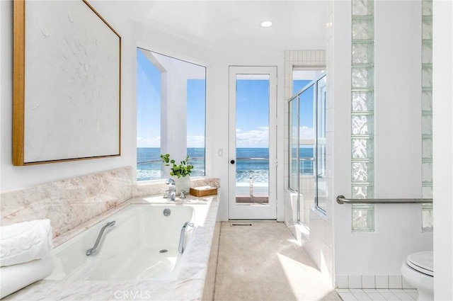 bathroom with a water view, tiled bath, tile patterned floors, and toilet