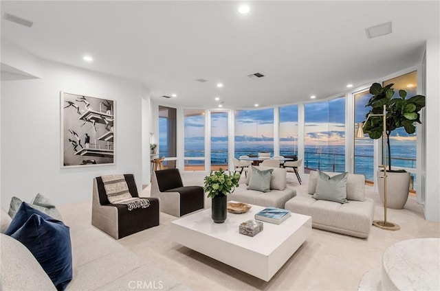 living room with a water view and floor to ceiling windows