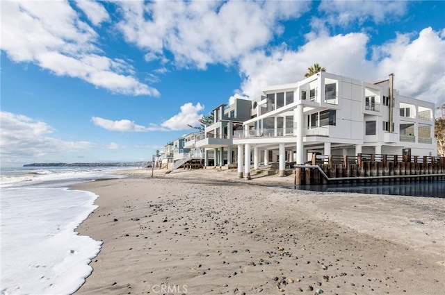 back of property with a beach view and a water view