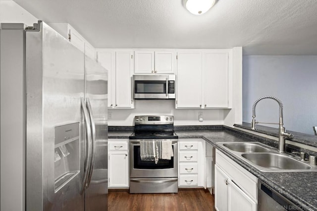 kitchen featuring sink, stainless steel appliances, a textured ceiling, and white cabinetry