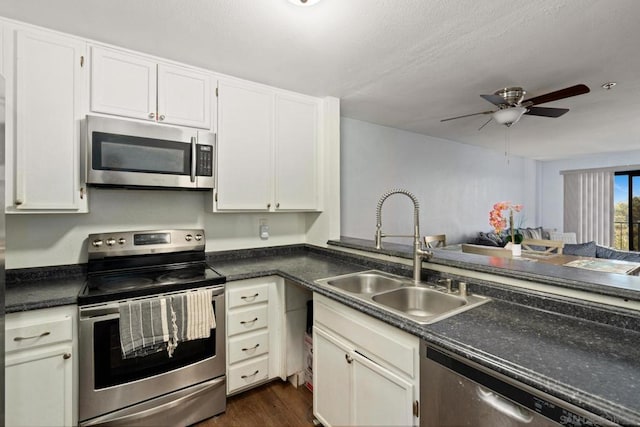 kitchen with appliances with stainless steel finishes, dark wood-type flooring, white cabinets, and sink