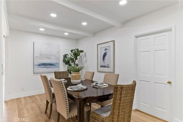 dining area featuring light hardwood / wood-style floors and beam ceiling