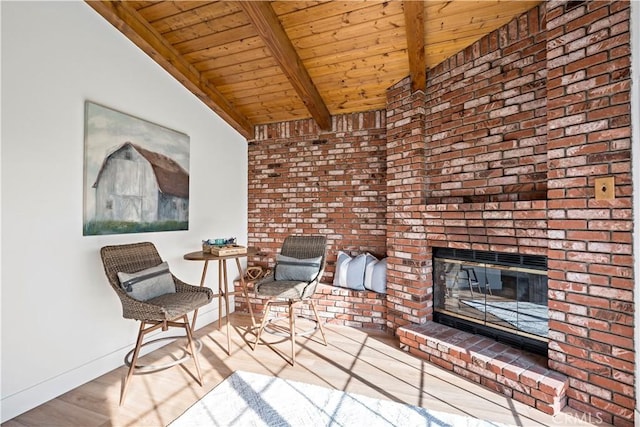 living area featuring a brick fireplace, hardwood / wood-style flooring, lofted ceiling with beams, and wood ceiling