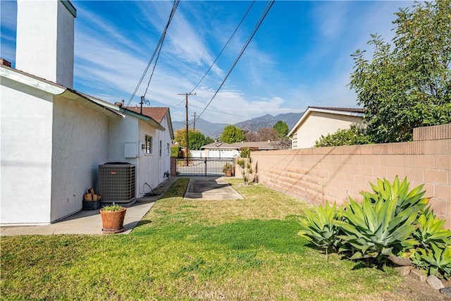 view of yard featuring a mountain view and central AC unit