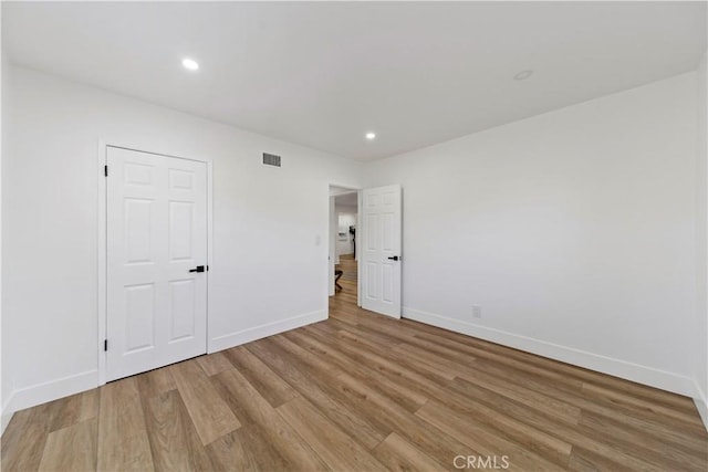 unfurnished bedroom with light hardwood / wood-style floors and a closet