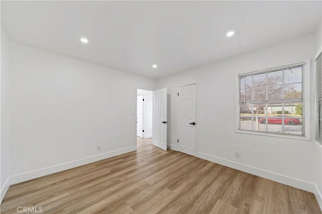 empty room with light hardwood / wood-style flooring