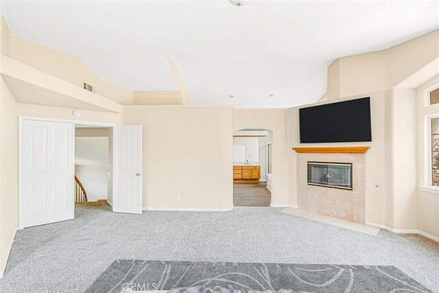 unfurnished living room featuring a tile fireplace and carpet flooring