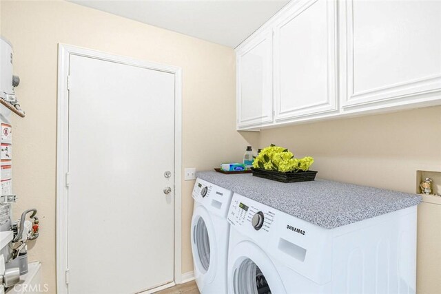 laundry room with cabinets, light tile patterned floors, and independent washer and dryer