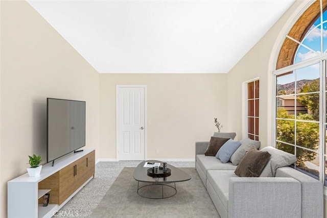 carpeted living room featuring lofted ceiling