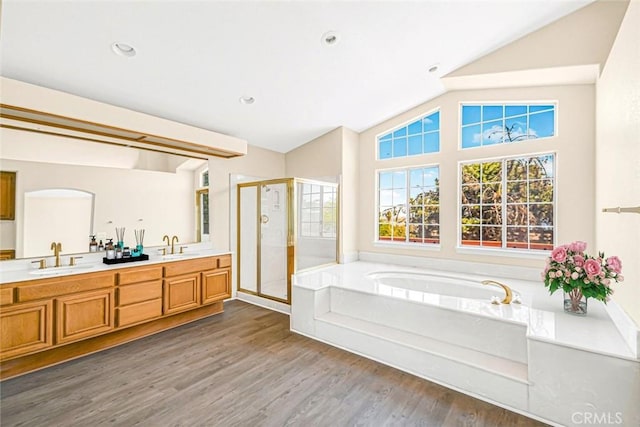 bathroom featuring hardwood / wood-style floors, vanity, independent shower and bath, and vaulted ceiling