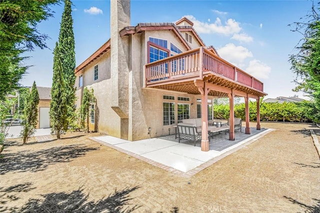 back of property featuring a wooden deck and a patio