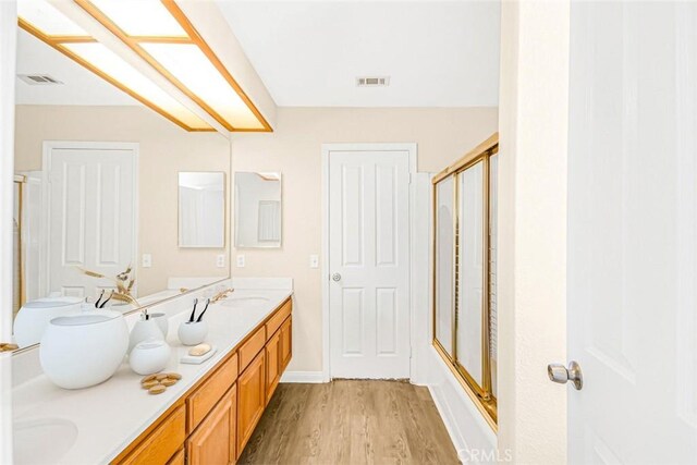 bathroom featuring vanity, wood-type flooring, and an enclosed shower