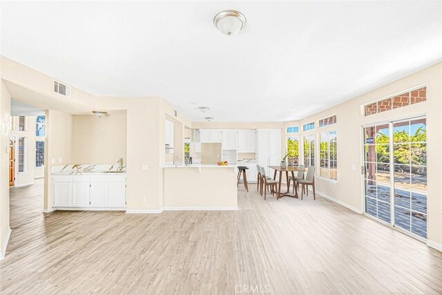 unfurnished living room featuring sink and light wood-type flooring