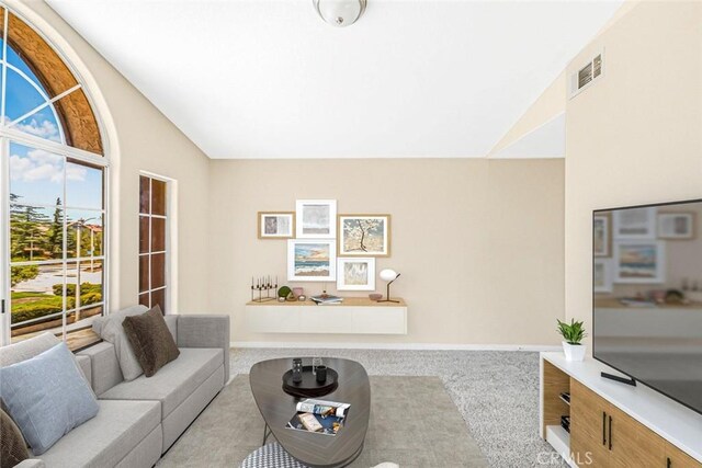 living room featuring vaulted ceiling and light carpet