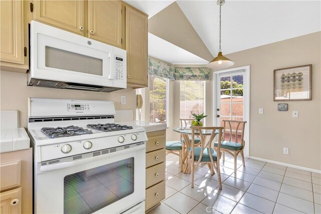 kitchen with vaulted ceiling, tile countertops, pendant lighting, white appliances, and light tile patterned floors