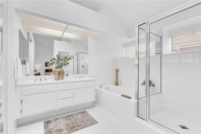 bathroom featuring plus walk in shower, vaulted ceiling, tile patterned floors, and vanity