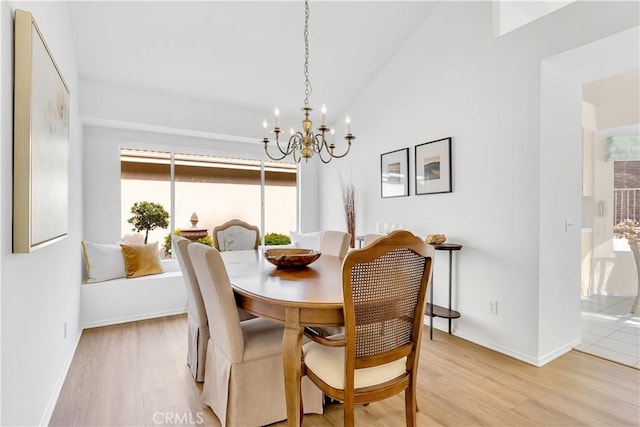 dining space featuring vaulted ceiling, a chandelier, and light hardwood / wood-style floors