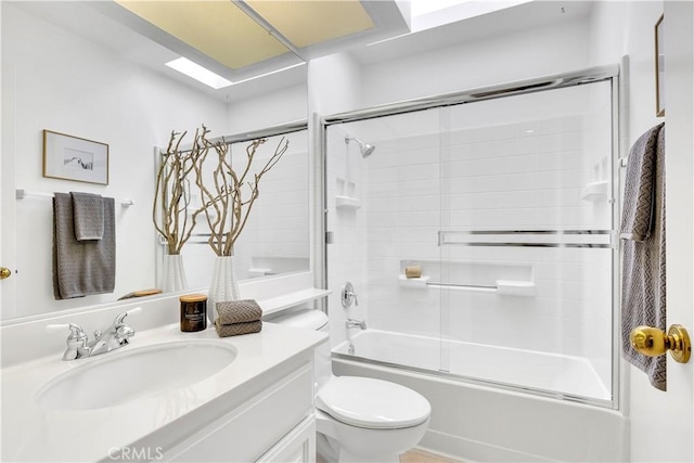 full bathroom featuring shower / bath combination with glass door, vanity, and toilet