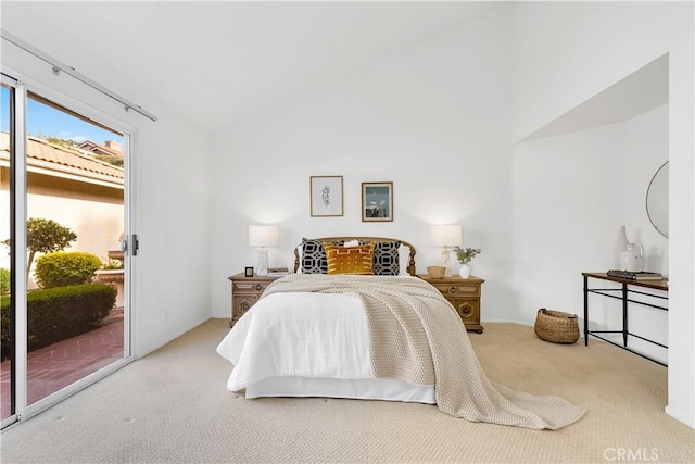 bedroom featuring light carpet, access to exterior, and vaulted ceiling