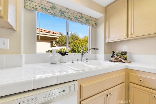 kitchen with sink, dishwasher, and tile countertops