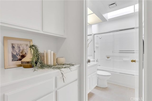 bathroom featuring combined bath / shower with glass door, tile patterned floors, and toilet