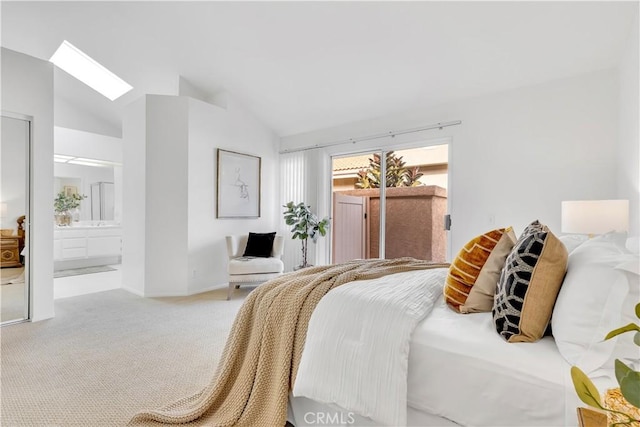 carpeted bedroom featuring ensuite bathroom, lofted ceiling with skylight, and access to outside