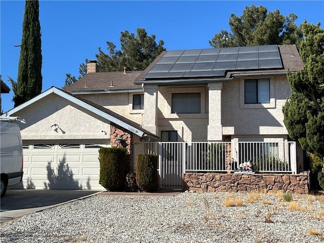 view of front facade with a garage and solar panels