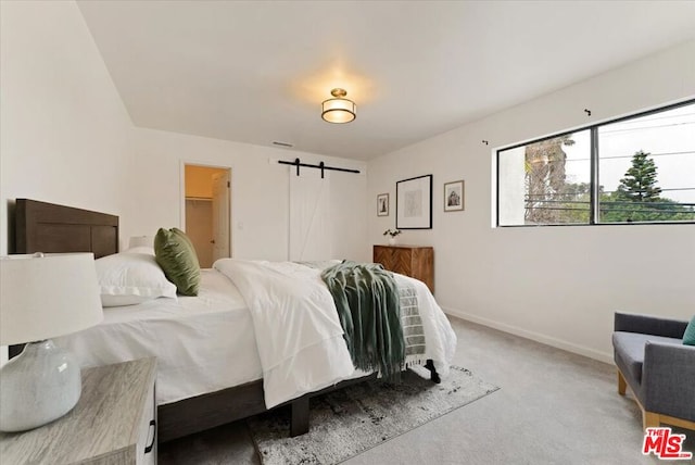 carpeted bedroom featuring a barn door