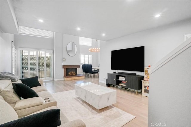 living room with an inviting chandelier and light hardwood / wood-style flooring