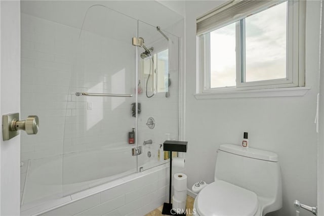 bathroom with shower / bath combination with glass door and toilet