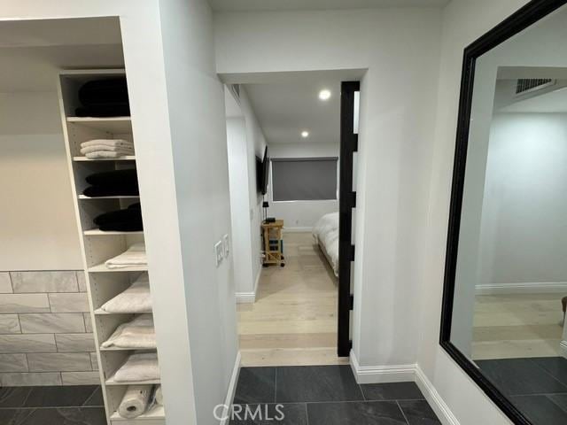 hallway with dark tile patterned flooring