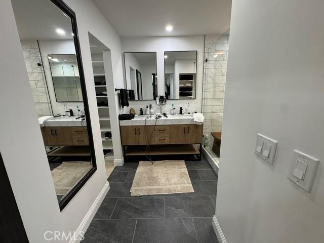 bathroom with a shower with shower door and vanity