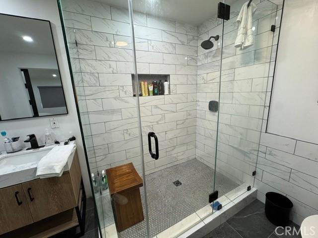 bathroom with tile patterned floors, an enclosed shower, and vanity